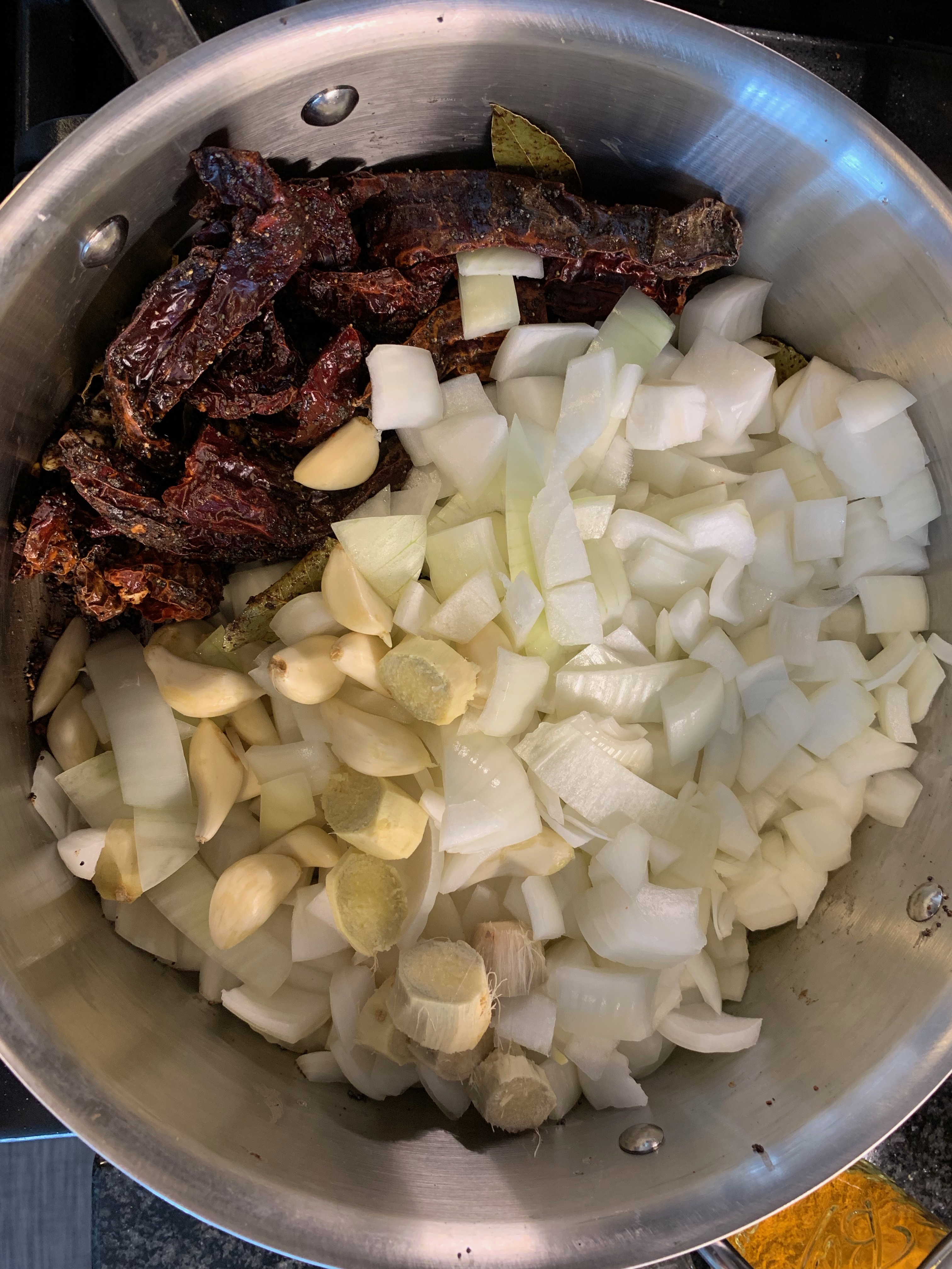 Onion, garlic, ginger, and dried chilies in the pot