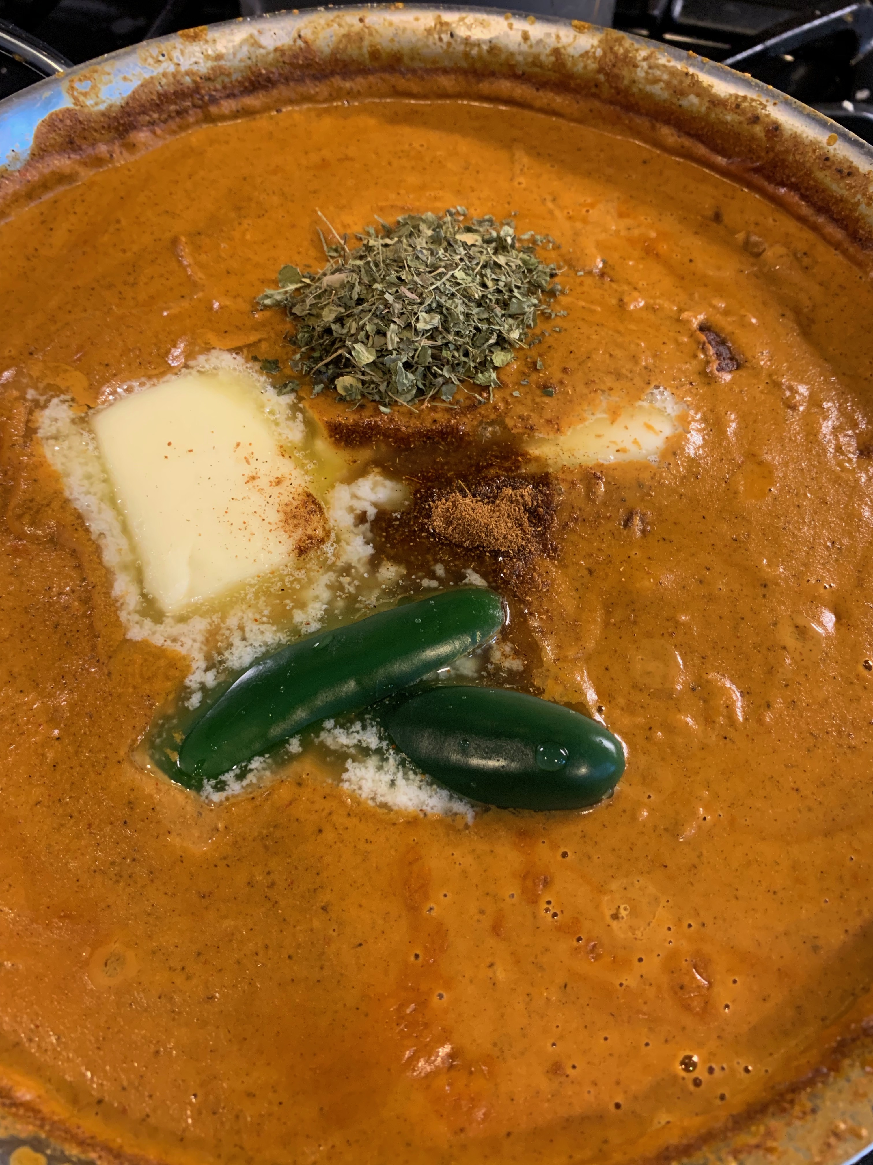 Finishing the sauce with butter, kasuri methi, and green chilies